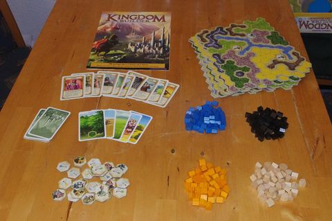 a set of material for the game Kingdom Builder on a wooden table
