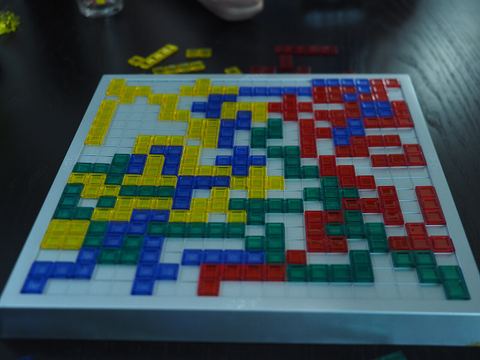 A two-player game of Blokus in the middle of play. One player is playing red and yellow, the other is playing blue and green. All colours compete against each other as normal, the only difference is that each player has multiple colours under their control.
